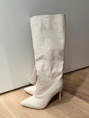 Höga stövlar - Snygga cremefärgade stövlar med spetsig tå och hög klack.  Perfekta för att lyfta vilken outfit som helst.