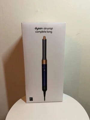 Dyson Airwrap Complete Long - Säljer en Dyson Airwrap Complete Long i snygg blå och kopparfärg. Setet innehåller flera olika stylingtillbehör för att skapa lockar, vågor och volym. Perfekt för dig som vill fixa håret snabbt och enkelt med en multifunktionell hårstyler. Hel ny , finns i Göteborg 