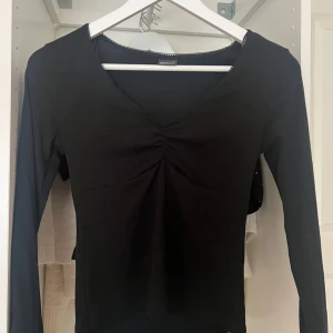 Svart långärmad tröja  - En svart långärmad tröja med lite detaljer. Andvänt några fåtal gånger så den är i mycket bra skicka!! Pris kan diskuteras.