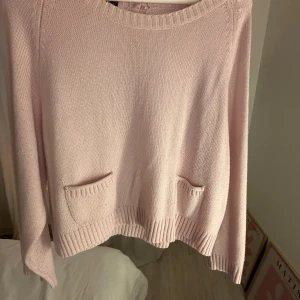 Ljusrosa stickad tröja med fickor - Söt ljusrosa stickad tröja med två små fickor framtill. Tröjan har rundad hals och ribbade muddar vid ärmslut och nederkant. Säljer pga av att den är för liten, älskar den!🩷 hör av er om frågor, denna säljs inte längre!