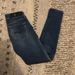 Replay skinny jeans blå, midwaist - Snygga blå skinny jeans från Replay med klassisk femficksdesign och guldfärgade sömmar. Modellen är midwaist och har en lätt tvättad look. Perfekta för dig som gillar en tight passform och stilren design. Jeansen är i nyshick och i jätte bra kvalité, priset är inte inhugget i sten och kan diskuteras. Vid några frågor hör av er👍