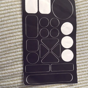 Skärmskyddskit för elektronik - Ett ark med självhäftande skydd i olika former och storlekar, perfekt för att skydda knappar, skärmar och känsliga delar på elektronik. Passar till mobiltelefoner, surfplattor och andra enheter. Produkten är ny och oskadad.