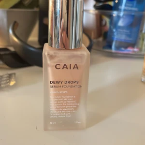 CAIA Dewy Drops Serum Foundation 10W - CAIA Dewy Drops Serum Foundation i nyansen 10W. Kommer i en frostad glasflaska med silvrig pump. Innehåller 30 ml och är berikad med vitamin E och glycerin för återfuktning och en naturlig, glowig finish. ‼️‼️.‼️använd fåtal gånger pgr av fel färg! Se på bilderna hur mycket det är kvar‼️‼️