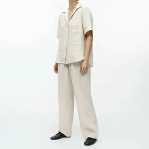 Beiga vida linnebyxor - Säljer ett par beiga linnebyxor med avslappnad och vid passform. Byxorna har en rak siluett och är tillverkade i svalt linnematerial, perfekta för varma dagar. De har en enkel och stilren look som passar till många olika outfits.