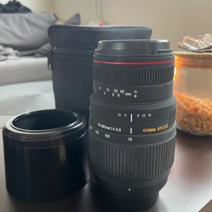 Sigma 70–300mm f/4–5.6 DG Macro (Nikon F) - Säljer mitt Sigma 70–300 mm f/4–5.6 DG Macro-objektiv för Nikon-kameror. Objektivet kommer med ett motljusskydd och ett fodral. (Det som syns på bilden) Fungerar som det ska.  Fattning: Nikon F