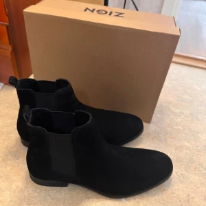 Svarta chelsea boots från Zign, stl 43 - Jätte eleganta herrskor i storlek 43 från märket ZIGN köpta från zalando. Dem köptes till ett speciellt tillfälle och har använts endast två gånger. Kommer i sin originala förpackning. Köptes för drygt 900kr