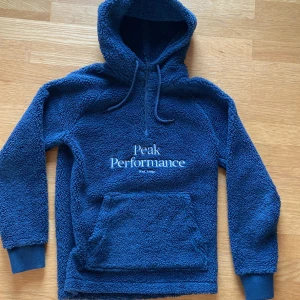 Blå fleece hoodie Peak Performance - Riktig bekväm och mysig peak performance kofta perfekt till det kallare vädret. Använd fåtal gånger och är i riktigt bra skick. Skriv vid funderingar 