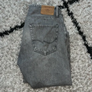Grå jeans från Jack & Jones, storlek 32/32 - Säljer ett par grå jeans från Jack & Jones i storlek 32/32 för endast 150kr! Jeansen har klassisk femficksdesign, raka ben och snygg tvättad look. Perfekta för dig som gillar en stilren och avslappnad vibe. Materialet är mjukt och bekvämt jeans. 