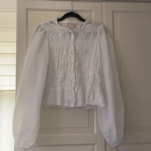Vit blus från Nelly - Supersöt vit blus från Nelly i storlek 34 (xs). Blusen har lång puffärm och knappt framtill. (Flirty smock blouse) ordinarie pris 399kr. Använd 1 gång. Skriv om du har nån fråga💕💕