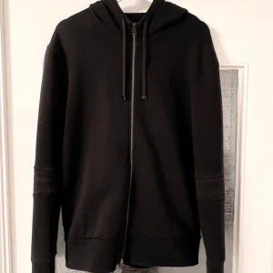 Svart hoodie från Hugo Boss - Svart hoodie från Hugo Boss med dragkedja och huva. 