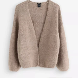 Trendig Beige stickad kofta från Lindex - Mysig beige stickad kofta från Uniqlo med avslappnad passform och djup v-ringning. Koftan har långa ärmar och är perfekt att slänga på sig över en t-shirt eller topp. Enkel och stilren design som passar till det mesta. Lite nopprig i storlek xs/s