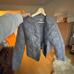 Grå jacka från mango - Säljer nu min gråa mango jacka som jag älskar, men säljer pga av att den är för liten! Den har ett vågigt mönster i sömmarna. Jackan har rund halsringning, knappar framtill och är lätt vadderad. Perfekt för hösten och trendig stil! Fråga om ni har några funderingar!💓 Har nästan aldrig använt den pga att den var för liten efter ett år!