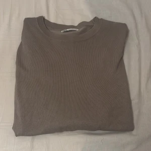 Brun stickad tröja från Zara - En enkel och stilren brun stickad tröja från Zara i storlek S. Tröjan har rund halsringning och är tillverkad i ett mjukt stickat material. Pris kan diskuteras!