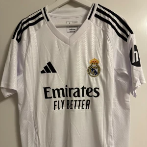 Bellingham Real Madrid fotbollströja - Lag och säsong: Real Madrid hemmatröja 2024/2025 Namn: Bellingham #5 Storlek: M Skick: Oanvänd med lapp kvar. Reprint