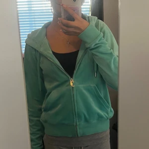 Turkos Juicy Couture hoodie i velour - Säljer en turkos hoodie från Juicy Couture i mjuk velour med dragkedja och huva. Skulle säga att den är i nyskick då jag endast använt den ca 4 ggr😅PRIS KAN DISKUTERAS