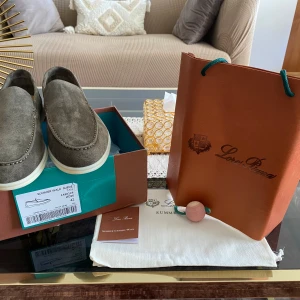 Loro Piana Summer Walk mockaloafers - Snygga loafers från Loro Piana i modellen Summer Walk. Skorna är i mjuk grå mocka med vita sulor och har en klassisk, stilren design. Perfekta för dig som gillar exklusiva och bekväma skor med premiumkänsla. Kommer med originalkartong och dustbag.