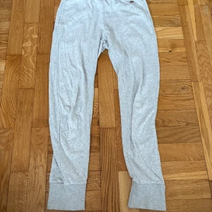 Ljusgrå mjukisbyxor i bomull - Ljusgrå mjukisbyxor från Ü i storlek 146. Byxorna har breda muddar vid bensluten och är tillverkade i mjukt bomullsmaterial. Perfekta för chill dagar eller när du vill vara extra bekväm.