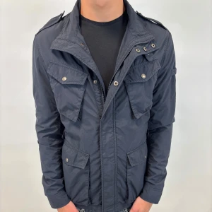 Woolrich Jacka - Hej! Säljer nu denna väldigt snygga och eftertraktade Woolrich Fieldjacka!  Jackan är slutsåld överallt och går inte att få tag på… jackan är perfekt nu till hösten/vintern  Storlek L  Skick 9,5/10  Ny pris: 6000 kr Säljs för: 1299 kr