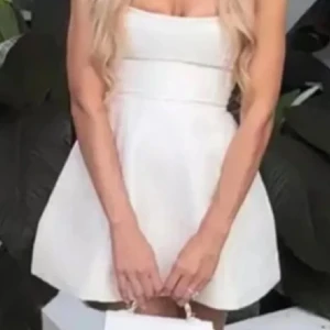 Vit mini-klänning Showpo - Supersöt vit miniklänning i satin med smala axelband och figurnära överdel. Klänningen har en lätt utsvängd kjol och stilren design som ger en chic och fräsch look. Perfekt för dig som vill sticka ut med en enkel men elegant stil. Perfekt inför studenten 💓💓💓 helt ny, nypris ca 900