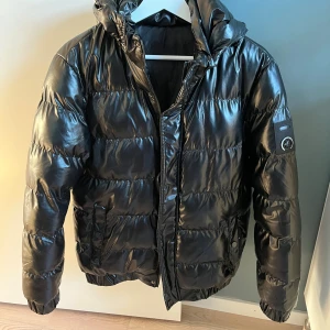 Snygg glansig vinterjacka - Säljer en snygg vinter jacka som är väl använd (därav billiga priset). Dragkedjan är ett gem och båda fickorna har är skadade och lagade. Ingen av deffekterna syns dock under använding. Hör av er för frågor eller bilder. 