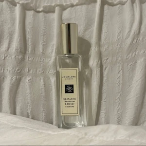 Jo Malone Nectarine Blossom Cologne - Fräsch och stilren cologne från Jo Malone London. Nectarine Blossom & Honey kommer i en snygg förpackning med blom- och fruktmotiv. Flaskan rymmer 30 ml – perfekt att ta med överallt.