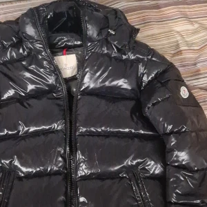 Svart pufferjacka från Moncler - "Nfc skannen funkar" Säljer en helt ny/ oanvänd moncler jacka. Storleken är m (den var lite för liten på mig vid armarna som är 183 cm 80kg) ( ifall du har nå frågor om storlek är det bara att skriva till mig)                                                svart moncler jacka  glansig pufferjacka från Moncler med huva och dragkedja. Jackan har klassisk Moncler-logga på ärmen och quiltad design. Perfekt för kalla dagar med sin fluffiga och varma känsla. 
