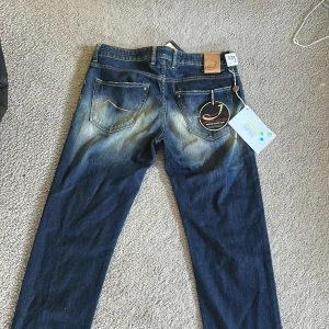 Jacob Cohën blå jeans, stl 32 - Snygga blå jeans från Jacob Cohën. Jeansen är helt nya med alla tags! Jeansen har en schysst tvätt med ljusare partier och kontrastsömmar. 