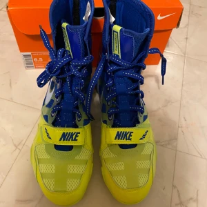 Nike HyperKO blue and yellow  - Nike HyperKO boxningsskor i blått och neongult. De är i storlek 39 och kommer i sin kartong, helt oanvända! Perfekta för dig som vill sticka ut i ringen. Lomochenko Edition!