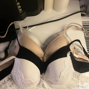 4 olika bh-ar - Säljer fyra olika toppar: en vit med spetsdetaljer, en beige, en svart och en ljusgrå, alla med smala axelband och mjuka kupor. Vit är från Cubus och i 65A och dom andra från Kappahl och i 65AA! Alla för 100kr