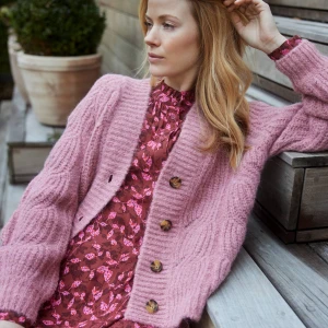 Blommig klänning från Noa Noa - Säljer en superfin blommig klänning från Noa Noa i vinrött med rosa och röda blommor. Klänningen har lång ärm, knytband i midjan och skjortkrage. Den är tillverkad i mjuk viskoskvalitet och har en avslappnad passform som ger en snygg siluett. Inga anmärkningar. 