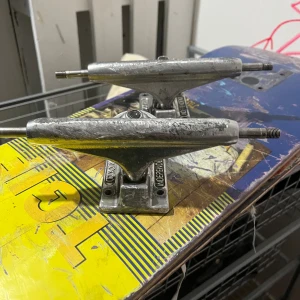 Independent  - Bilden visar skateboard-truckar. Truckarna är av märket Independent och har tydliga tecken på användning med repor och slitage, men ser fortfarande robusta ut. 