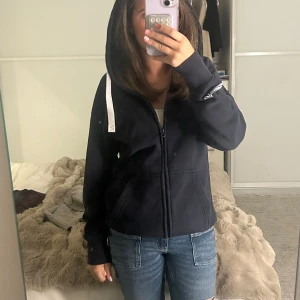 Mörkblå hoodie från Russedress - Använd några gånger men syns inte. Väldigt bra skicka och väll behandad! Storlek M men passar också S. Mörkblå hoodie från Russedress med vit dragsko och dragkedja framtill. Tröjan har huva, ribbade muddar och fickor på magen. Perfekt för chill dagar och enkel att matcha med jeans eller mjukisbyxor. 🥰🥰