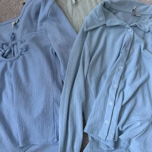 3 ribbade toppar från Nelly - Säljer tre snygga ribbade toppar från Nelly. En ljusblå långärmad topp med knyt vid halsringningen, en ljusblå blus med krage och knappar framtill samt en ljusbeige croppad topp med v-ringning och krage. Alla har lång ärm och mjukt stretchigt material. XXS och XS 💗