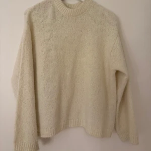 Krämvit stickad tröja Gina Tricot XS - Mysig krämvit stickad tröja från Gina Tricot i storlek XS. Tröjan har rund hals, ribbade muddar och långärmad passform. Perfekt för dig som gillar en enkel och clean look med lite oversized känsla. Supermjuk och fluffig, passar till jeans eller kjol.