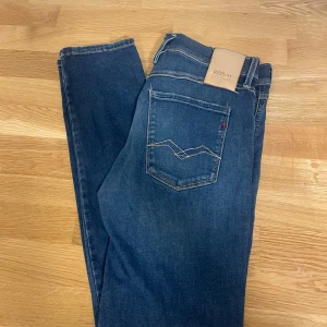 Replay Hyperflex Anbass jeans blå - Säljer ett par blå Replay Hyperflex Anbass jeans i slim fit. Klassisk femficksmodell med snygg broderad bakficka och skinnpatch i midjan. Jeansen är gjorda i stretchigt passform.