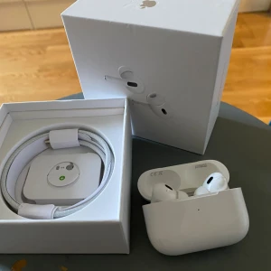 AirPods Pro (2nd generation) - Apple AirPods Pro (2nd gen) med originalförpackning och laddningskabel. Trådlösa hörlurar med aktiv brusreducering och laddningsetui. Mycket fint skick, inga synliga repor eller skador. Perfekt för musik, samtal och träning.