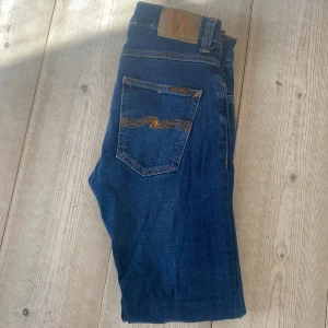 Mörkblå jeans från Nudie Jeans W28 L32 - Säljer ett par mörkblå jeans från Nudie Jeans modell Grim Tim. Fint skick. Storlek W28 L32.