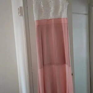 Långklänning med spets och rosa kjol - Superfin långklänning med vit spets upptill och ljusrosa, flowy kjol i tunt material.