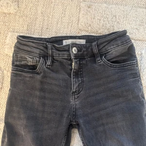 Bootcut svarta jeans från Mango - Snygga svarta jeans från Mango med bootcut passform och klassisk femficksdesign. Jeansen har en mörk tvätt med lätt slitning och är tillverkade i jeansmaterial med lite stretch. Perfekta för dig som gillar en avslappnad men trendig look.Tveka inte på att höra av dig vid frågor eller intresse!