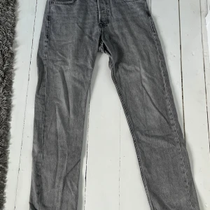 Grå jeans från Jack & Jones, 29/32 - Snygga grå jeans från Jack & Jones i modellen Jeans Intelligence. De har klassisk femficksdesign, raka ben och normal passform. Jeansen är tillverkade i mjukt bomullsmaterial och har en cool tvättad look som passar perfekt till sneakers.