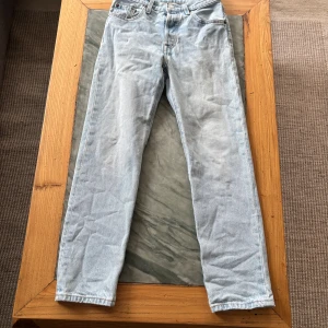 Levi's 501 ljusblå jeans straight fit - Ljusblå Levi's 501 Premium jeans med klassisk rak passform och fem fickor. Jeansen har knappgylf, bälteshällor och är tillverkade i slitstark bomullsdenim.