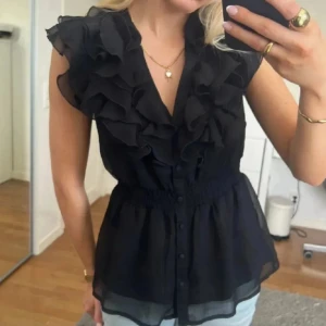 Svart blus med volanger och knappar - Blusenslapp är bort klippt men den är från hm 🩷🩷🩷 Skulle chansa att storleken är M 🫶☺️