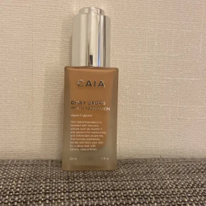 CAIA Dewy Drops Serum Foundation 30C - CAIA Dewy Drops Serum Foundation i nyansen 30C. Kommer i en snygg frostad glasflaska med silvrig pump. Ger en fräsch, daggig finish och innehåller vitamin E och glycerin för extra fukt. Perfekt för dig som vill ha en naturlig look med lyster. säljer så billigt för vill inte behöva slänga den då den är dyr o nästan helt oanvänd