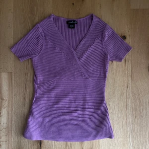 Topp - Lila tröja med korta ärmar. Köptes secondhand så vet inte hur ofta den används men har inga defekter. Säljer den då den inte är min stil längre.