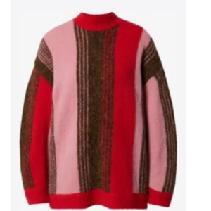 Randig stickad tröja i rött och rosa - Färgglad stickad tröja med breda vertikala ränder i rött, rosa och brunt. Tröjan har en hög hals och långärmad modell med en loose passform. Perfekt för dig som vill sticka ut med en mysig och trendig look.