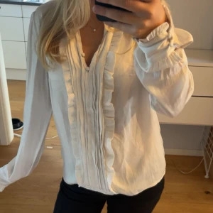 Vit skjortblus - Vit skjorta/blus med volanger. 