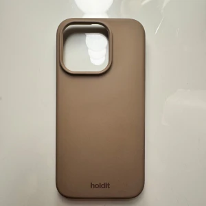 Holdit mobilskal iPhone 15 PRO - Säljer ett beige skal från Holdit till iPhone 15 PRO. I hel het i helt okej skick, finns en defekt på höger sida. 