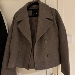 kort kappa i beige - superfin kort kappa i beige/brun. kommer tyvärr inte till användning så därav säljer jag den. använd fåtal gånger. inga skador
