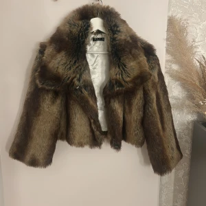 Brun pälsjacka från Vila, stl M - Säljer en brun pälsjacka från Vila i storlek M. Jackan har trekvartsärm (kortare ärmar) den har även en  innerficka och  knäppning. 