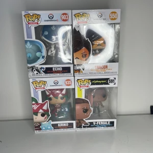 Funko Pop! Games Overwatch & Cyberpunk 2077 Set - Fyra Funko Pop! Games-figurer: Echo, Tracer och Kiriko från Overwatch samt V-Female från Cyberpunk 2077. Samtliga i originalförpackning med fönster, kartongerna ser ut att vara i mycket gott skick utan synligt slitage. Perfekt för samlare eller fans av spelen.
